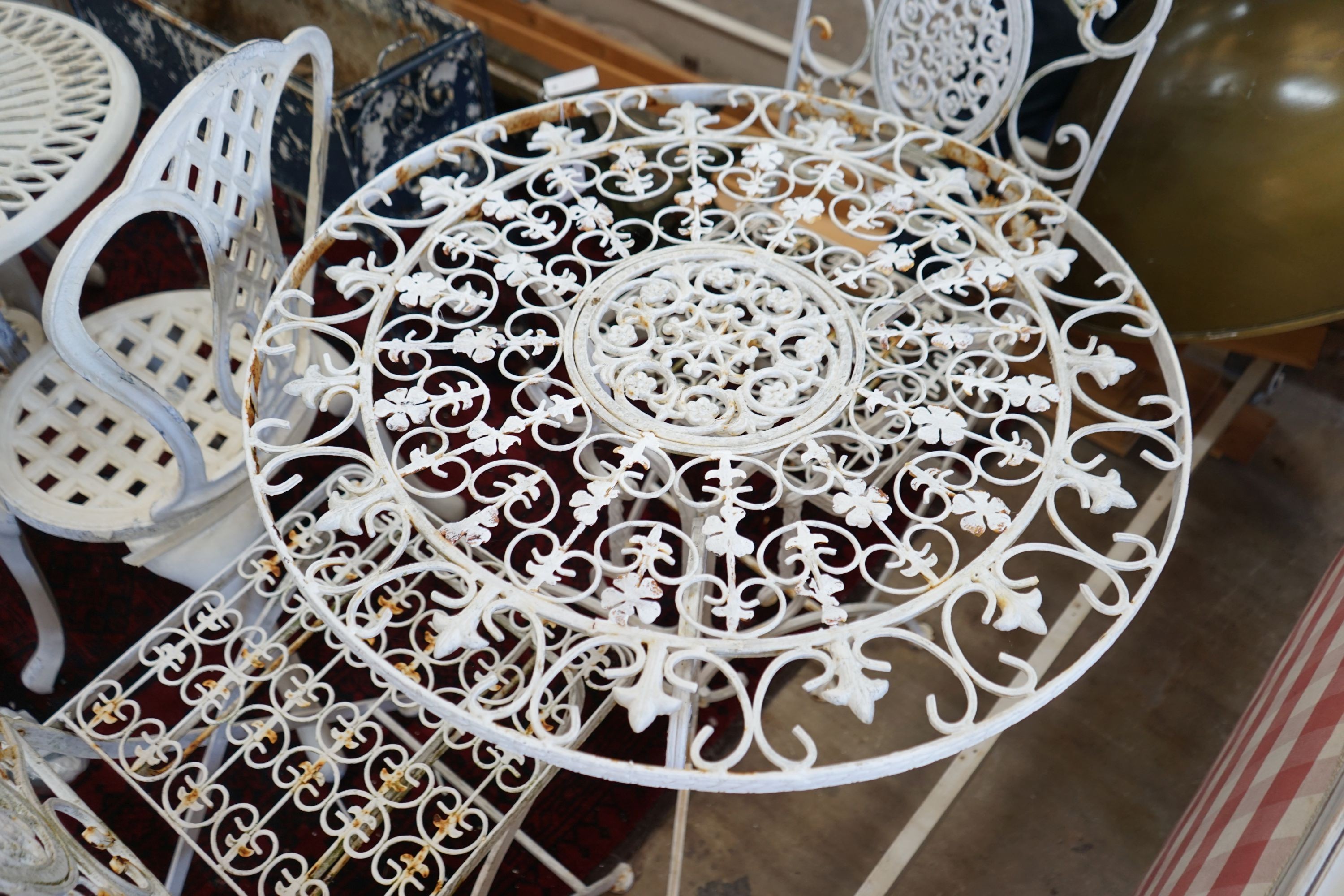 A painted circular metal garden table and 2 folding chairs, table 70 cms diameter.